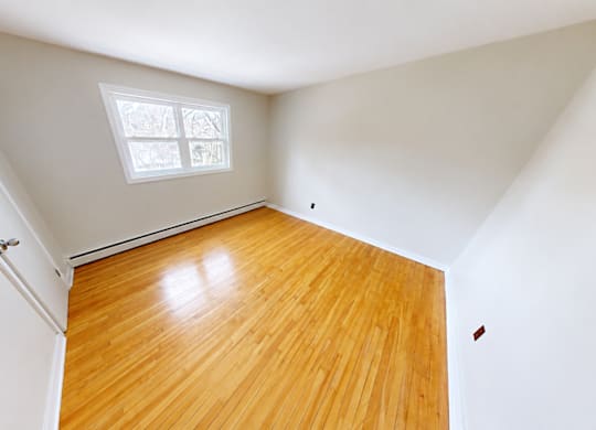 A room with a wooden floor and a skylight.