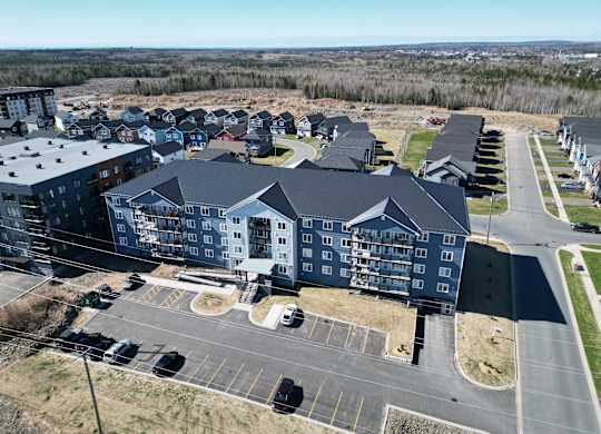 A large building complex with a parking lot in front.