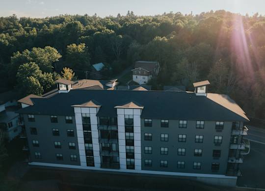 A hotel building with a sun flare in the background.