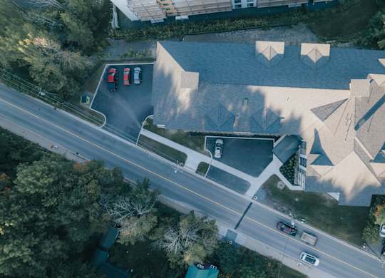 An aerial view of a road with cars and a building with a unique design.