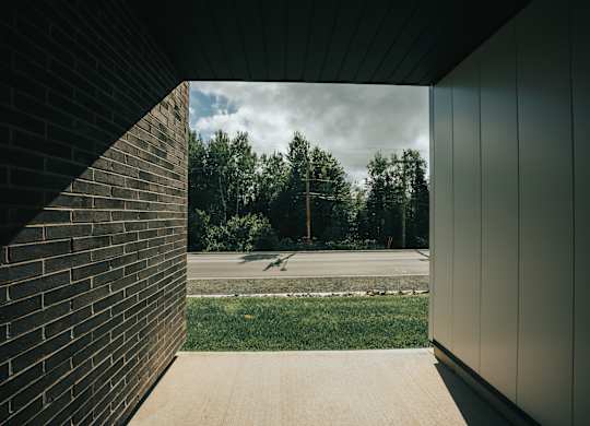A view from a building looking out to a grassy area with trees.