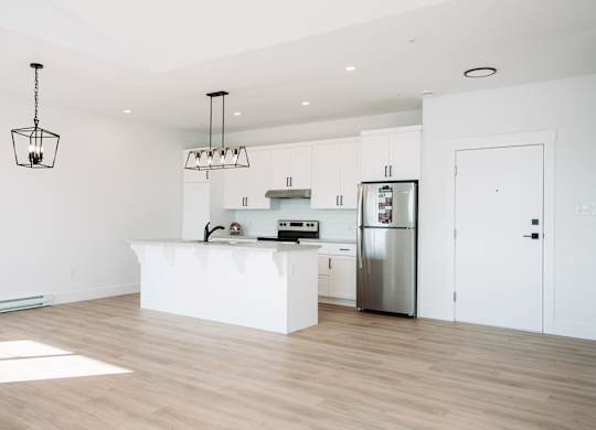 A kitchen with a white island and stainless steel appliances.