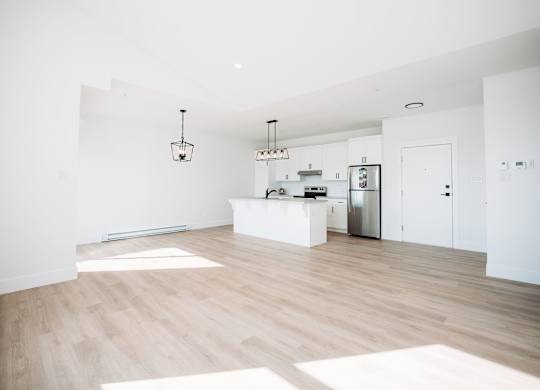 A kitchen with a refrigerator, sink, and cabinets.