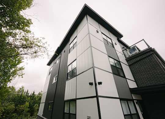 A modern black and white building with a triangular roof.