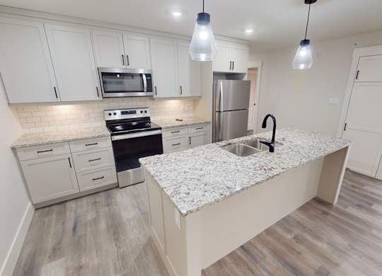 A kitchen with a granite countertop and a sink.