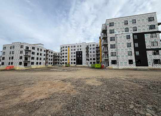 A large building with a lot of windows is under construction.