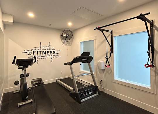 A gym with a pull up bar and a mirror.