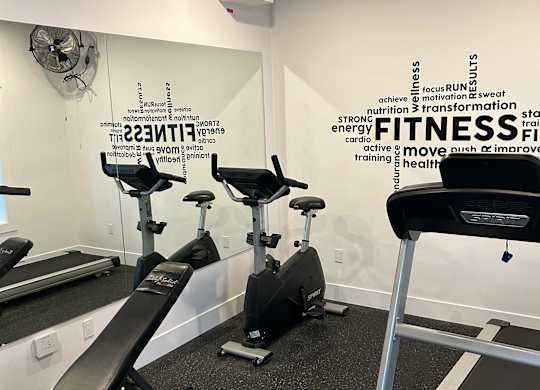 A gym with a treadmill and a sign that says "FITNESS".