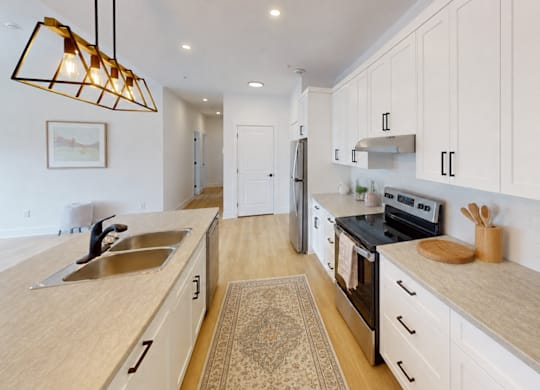 A kitchen with a sink, stove, and oven.