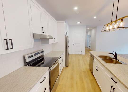 A kitchen with white cabinets and a wooden countertop.