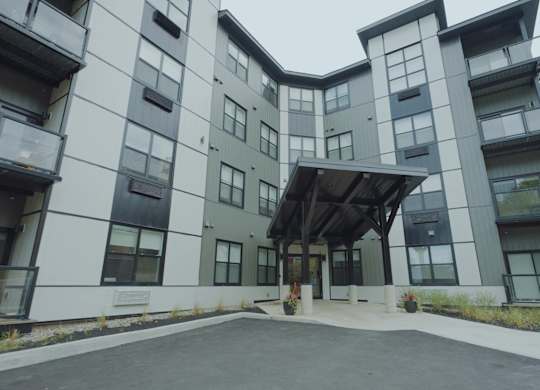 A modern building with a white and grey exterior and a black roof.