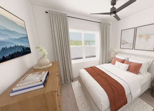 A bedroom with a large bed and a ceiling fan.