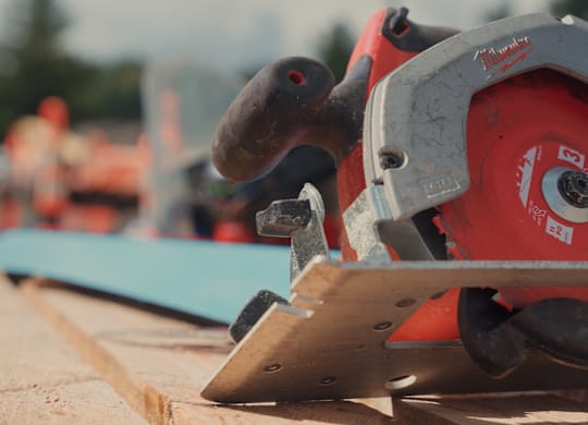 A circular saw is cutting a piece of wood.