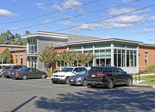A parking lot with cars and a building in the background.