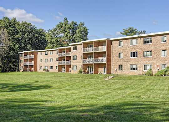 A large apartment complex with a green lawn in front.