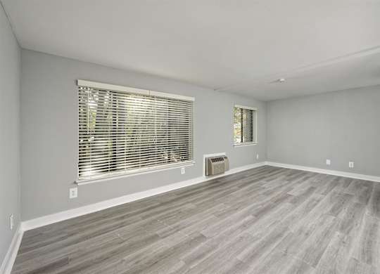 A room with a window and wooden flooring.