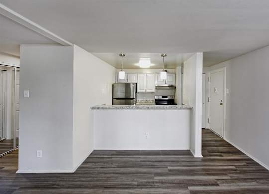 A kitchen with white cabinets and a white island with a countertop.
