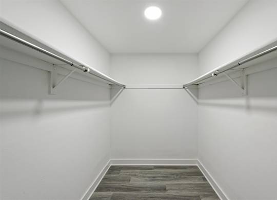 A long hallway with a wood floor and white walls.