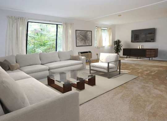 A living room with a grey sofa and a white chair.
