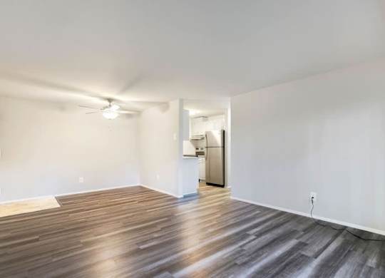 A room with wooden flooring and a ceiling fan.