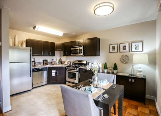 A kitchen with a table and chairs in the middle of it.