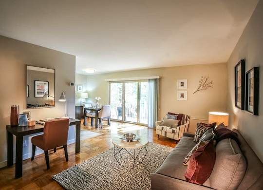 A living room with a couch, chairs, and a dining table.