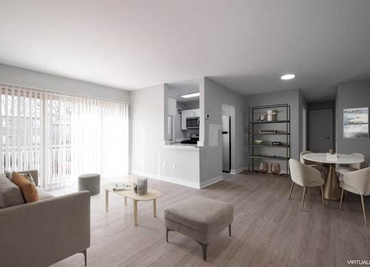 A modern living room with a grey couch, a coffee table, and a dining table set up.