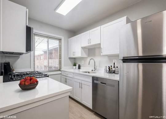A modern kitchen with stainless steel appliances and white cabinets.