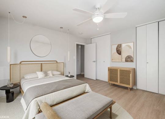 A bedroom with a large bed and a wooden headboard.