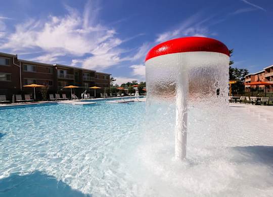 A water fountain in the middle of a pool.