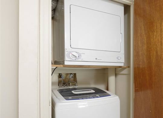 A white dishwasher is built into a cabinet under a microwave.
