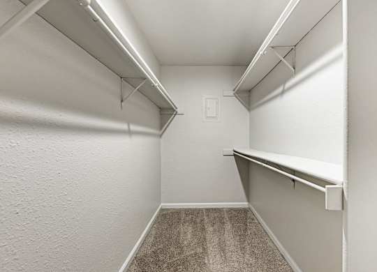A white hallway with a carpeted floor and white walls.
