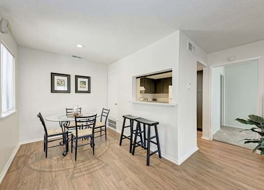 A dining room with a white table and chairs.