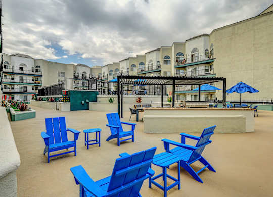 A patio with blue chairs and tables.