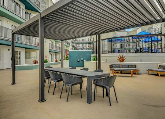 A patio with a table and chairs under a roof.