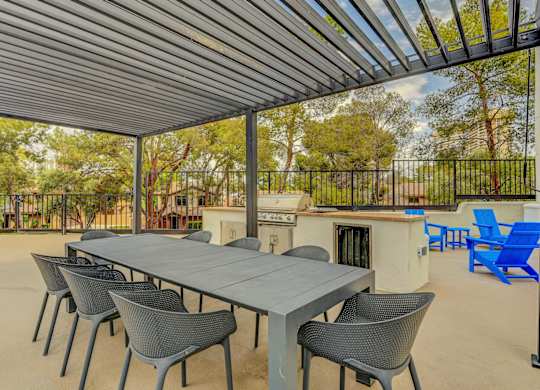 A patio with a table and chairs under a roof.