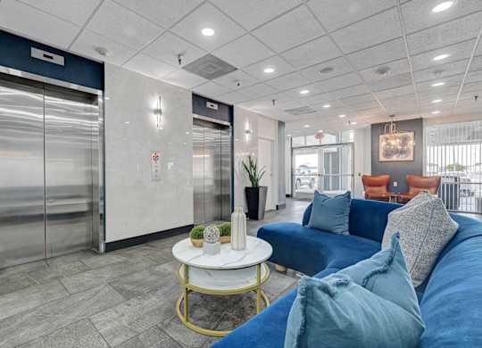 A living room with a blue couch and a white coffee table.