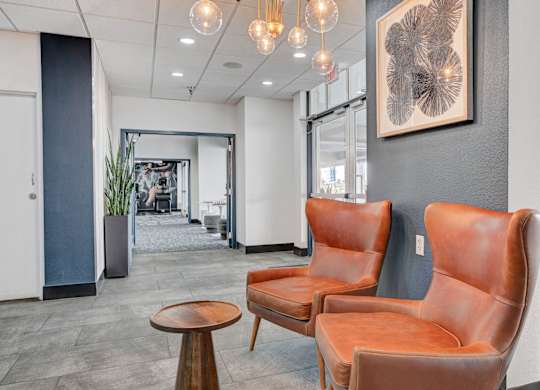 Two brown leather chairs and a table in a room.