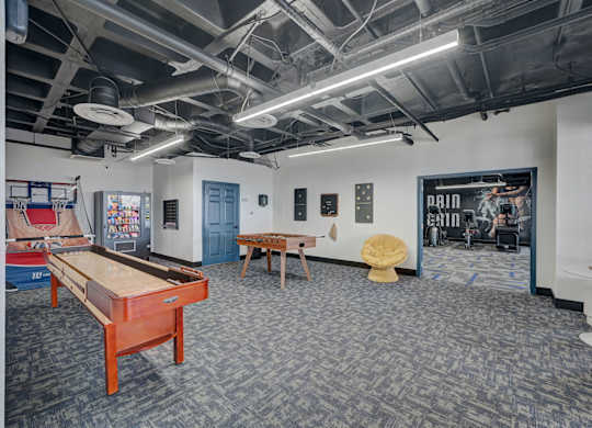 A room with a pool table and a foosball table.