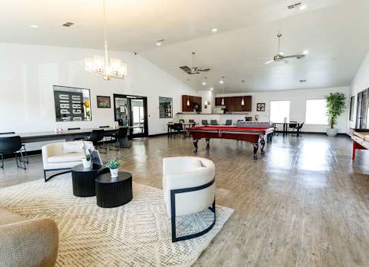 A spacious living room with a variety of furniture and a large rug.