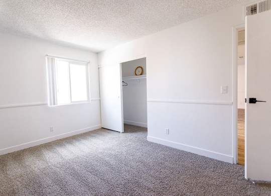 A room with a carpeted floor and a white door.
