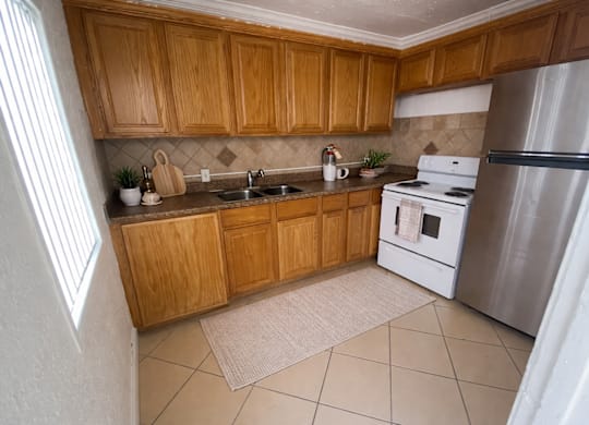 A kitchen with wooden cabinets and a white refrigerator.