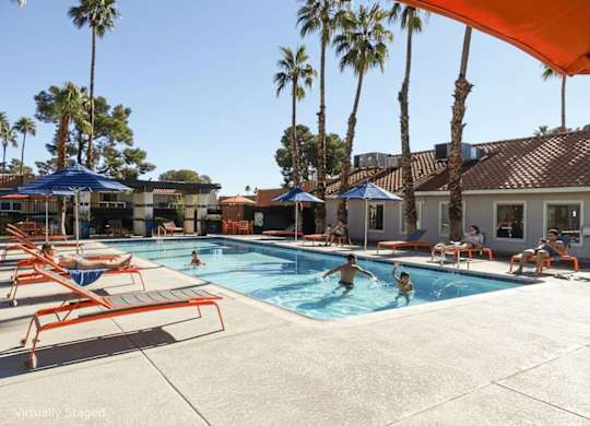 A group of people are enjoying a sunny day at the pool.
