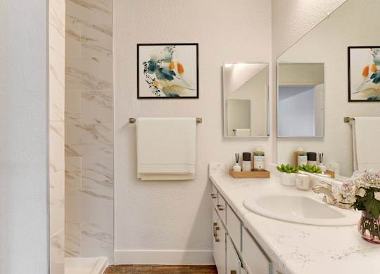 A bathroom with a marble wall and a white sink.