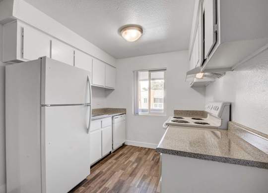 A kitchen with white appliances and a window.