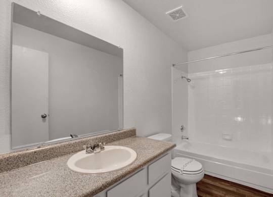 A bathroom with a sink, toilet, and bathtub.
