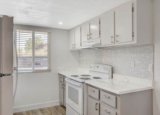 A kitchen with white appliances and cabinets.