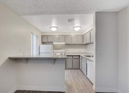 A kitchen with white cabinets and a refrigerator.