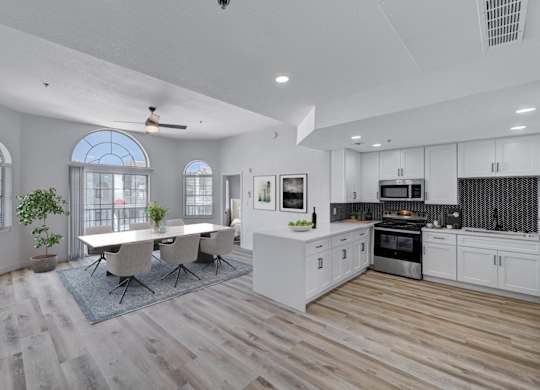 A modern kitchen with a dining table and chairs.