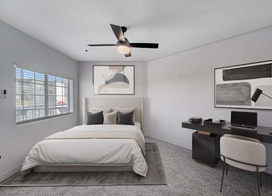 A bedroom with a bed, desk, and chair.